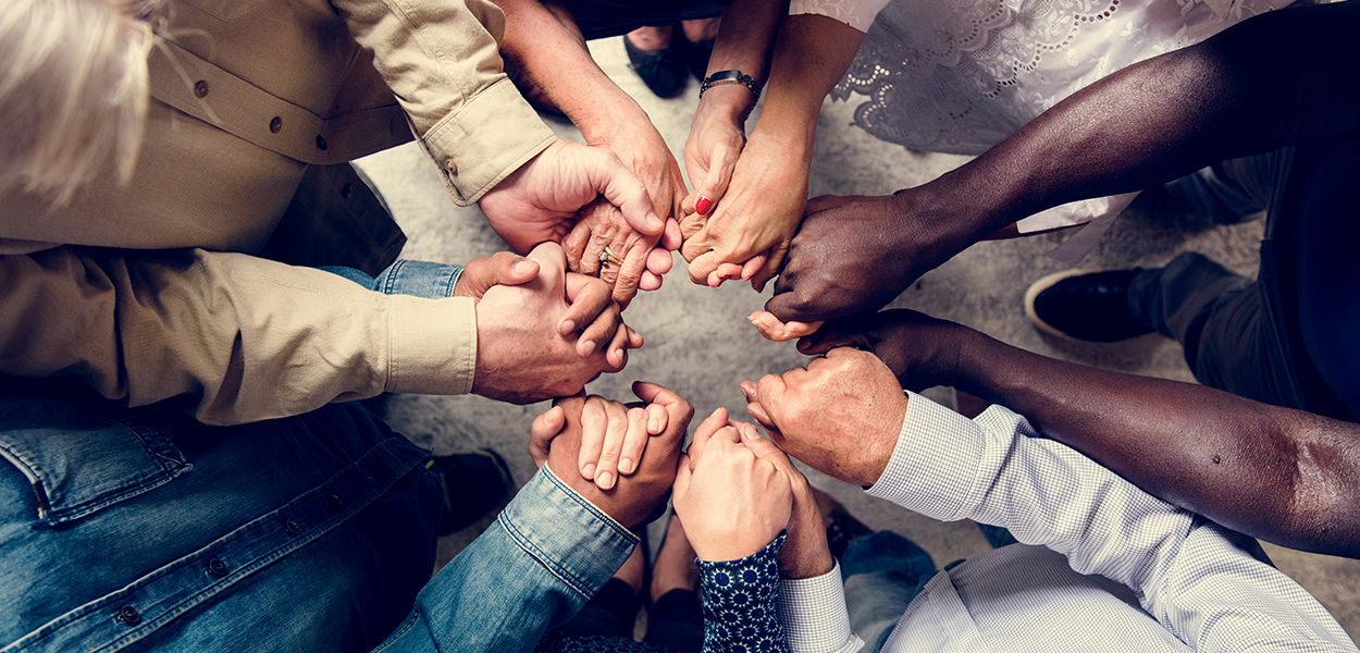 Group of people holding hand in a curcle
