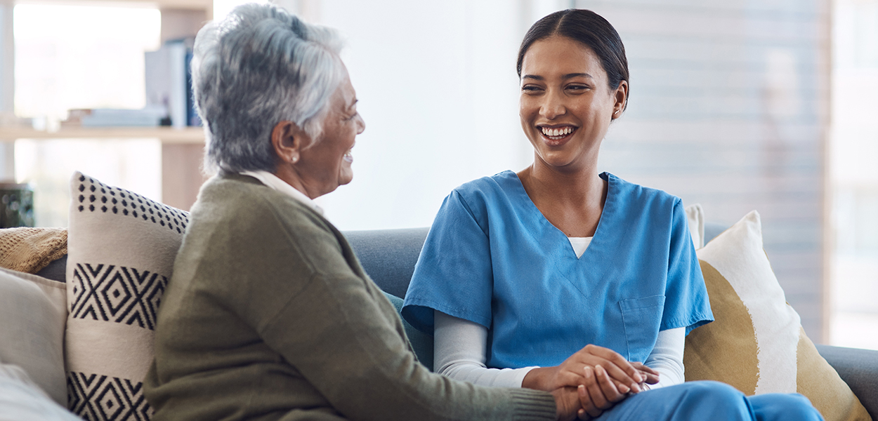 Image of nurse sitting and talking with an elderly person.
