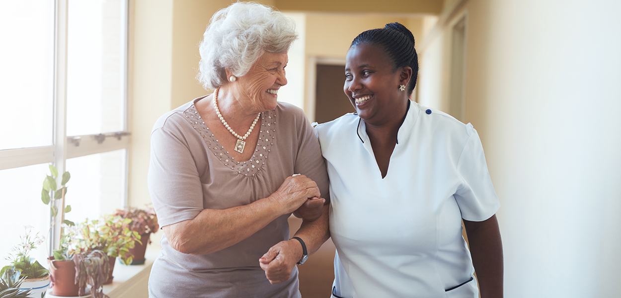 Image of nurse holding elderly person's hand